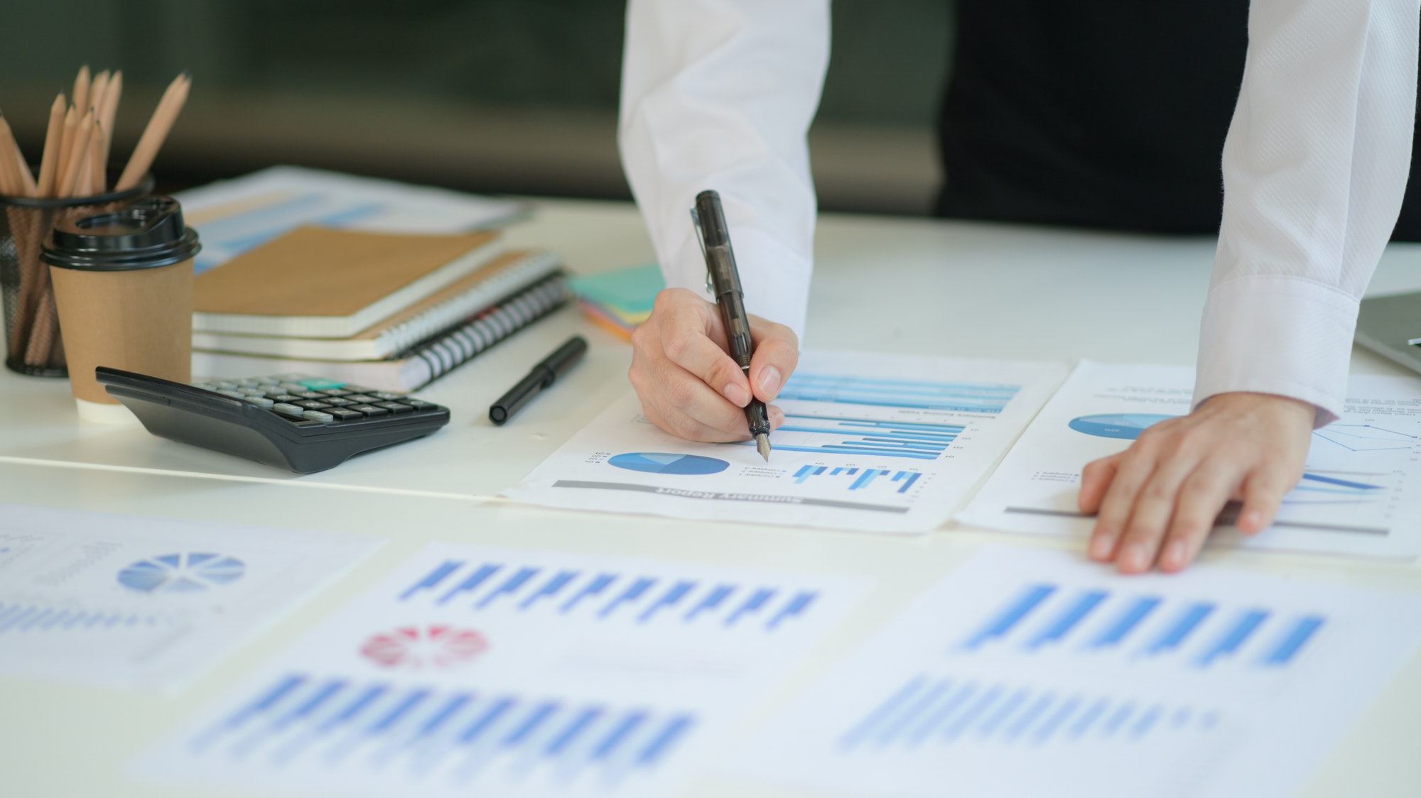 Business professionals reviewing insurance documents and financial reports in a corporate setting, risk management and tax protection concept